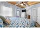 Bright bedroom with wood ceiling features a television, white dresser, and bathroom access at 722 Gulf Blvd, Indian Rocks Beach, FL 33785