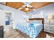 Well-lit bedroom features wood ceiling with fan, white curtains, seashell themed bedding, and view of doorway at 722 Gulf Blvd, Indian Rocks Beach, FL 33785