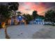 Charming homes amidst lush greenery, enhanced by a vibrant sunset sky at 722 Gulf Blvd, Indian Rocks Beach, FL 33785