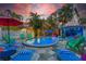 Inviting backyard pool area with lounge chairs, landscaping, and a colorful cabana at 722 Gulf Blvd, Indian Rocks Beach, FL 33785