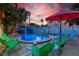 Beautiful backyard pool area with mature palms, tropical landscaping, lounge chairs and a cabana at 722 Gulf Blvd, Indian Rocks Beach, FL 33785