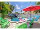 Backyard pool area with lounge chairs, tropical umbrellas, and a cute cabana at 722 Gulf Blvd, Indian Rocks Beach, FL 33785
