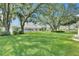 Lush backyard featuring a well-maintained lawn and mature trees, perfect for outdoor activities at 746 Masterpiece Dr, Sun City Center, FL 33573