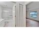 Bathroom and bedroom view; bathroom with tub/shower combo and bedroom with wood look floors at 746 Masterpiece Dr, Sun City Center, FL 33573