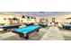 Spacious billiard room with multiple pool tables, overhead lighting, and seating for players at 746 Masterpiece Dr, Sun City Center, FL 33573