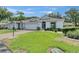 Charming home featuring a well-manicured lawn and a brick-paved driveway leading to an attached garage at 746 Masterpiece Dr, Sun City Center, FL 33573