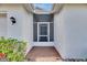 Inviting front porch with brick pavers, colorful flowers, and a secure screen door at 746 Masterpiece Dr, Sun City Center, FL 33573