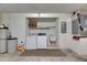 Garage area with laundry machines, shelving, sink, water systems, and the electrical panel at 746 Masterpiece Dr, Sun City Center, FL 33573