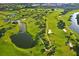 Scenic aerial view of a lush green golf course with winding fairways and tranquil water features at 746 Masterpiece Dr, Sun City Center, FL 33573