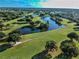 Aerial view of a beautiful golf course community featuring lush greenery and serene water hazards at 746 Masterpiece Dr, Sun City Center, FL 33573
