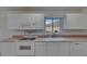 Well-lit kitchen featuring white cabinetry and modern appliances at 746 Masterpiece Dr, Sun City Center, FL 33573