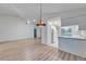 Open-concept living room and kitchen area featuring wood-look floors and bright, white kitchen cabinets at 746 Masterpiece Dr, Sun City Center, FL 33573