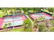 Aerial view of two tennis courts with green surroundings and partial shade from mature trees at 746 Masterpiece Dr, Sun City Center, FL 33573
