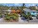Charming single-story home with red tile roof, surrounded by lush landscaping and mature palm trees at 819 Gulf Blvd, Indian Rocks Beach, FL 33785