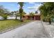 Inviting home with a gravel driveway, lush landscaping, and a classic red tile roof at 819 Gulf Blvd, Indian Rocks Beach, FL 33785