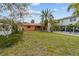 Landscaped lawn features a charming single-story home with red tile roof and gravel driveway at 819 Gulf Blvd, Indian Rocks Beach, FL 33785