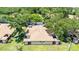 Aerial view of a well-maintained building with a light brown roof surrounded by green trees in a lush landscape at 8436 60Th N St # 304, Pinellas Park, FL 33781