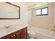 Bathroom featuring a vanity with dark wood cabinets, a standard bathtub, and a window at 8436 60Th N St # 304, Pinellas Park, FL 33781