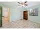 Spare bedroom with light walls, fan and a window, complemented by light laminate flooring at 8436 60Th N St # 304, Pinellas Park, FL 33781