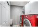 Laundry room has a red washer and dryer with storage cabinets and a utility sink at 8518 Tidal Bay Ln, Tampa, FL 33635
