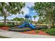 Community playground area featuring colorful play structure with two slides on a safety mulch surface at 8518 Tidal Bay Ln, Tampa, FL 33635