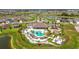 Beautiful aerial view of the community pool and clubhouse, including a playground and palm trees at 9577 Sandy Bluffs Cir, Parrish, FL 34219