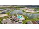 Community pool and clubhouse overlook a lake, and are surrounded by lush landscaping in an aerial view at 9577 Sandy Bluffs Cir, Parrish, FL 34219