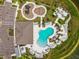 The community pool and playground are surrounded by beautiful landscaping and lounge chairs in this aerial view at 9577 Sandy Bluffs Cir, Parrish, FL 34219