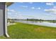 Lush backyard overlooking a serene lake, with a patio seating area to enjoy the beautiful waterfront views at 9577 Sandy Bluffs Cir, Parrish, FL 34219