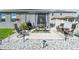 A backyard patio featuring outdoor dining and lounging spaces, surrounded by decorative rocks and landscaping at 9577 Sandy Bluffs Cir, Parrish, FL 34219