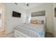 Cozy bedroom features a bed with white headboard, ceiling fan, and mounted television for relaxing evenings at 9577 Sandy Bluffs Cir, Parrish, FL 34219