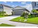 Charming home exterior features a wide driveway, well-maintained landscaping, and a welcoming facade at 9577 Sandy Bluffs Cir, Parrish, FL 34219