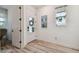 Welcoming foyer featuring wood-look floors, white walls, front door and interior door at 9577 Sandy Bluffs Cir, Parrish, FL 34219
