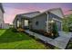 Charming gray house boasts a landscaped front yard with stone column accents and a welcoming entrance at 9577 Sandy Bluffs Cir, Parrish, FL 34219