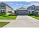 Charming home featuring a well-manicured front yard, landscaping, and gray garage door at 9577 Sandy Bluffs Cir, Parrish, FL 34219