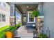Inviting front porch with stone accents, seating, and lush greenery creating a welcoming entrance at 9577 Sandy Bluffs Cir, Parrish, FL 34219