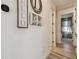 Hallway showcasing wall decor, thermostat, and wood-look flooring, leading to bedrooms with natural light at 9577 Sandy Bluffs Cir, Parrish, FL 34219