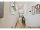 Hallway view with hanging plants, wall decor, wood-look floors, and view to the dining area at 9577 Sandy Bluffs Cir, Parrish, FL 34219