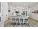 Modern white kitchen features a large island, stainless steel appliances, and stylish pendant lighting at 9577 Sandy Bluffs Cir, Parrish, FL 34219