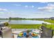 Outdoor seating area with lake view perfect for relaxing and dining alfresco at 9577 Sandy Bluffs Cir, Parrish, FL 34219