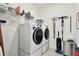 Functional laundry room with modern washer and dryer, and shelving for organized storage solutions at 9577 Sandy Bluffs Cir, Parrish, FL 34219