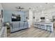 Open-concept living room and kitchen with light blue accent wall and wood-look flooring at 9577 Sandy Bluffs Cir, Parrish, FL 34219