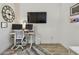 Modern office space featuring sleek desk setup, mounted TV, and neutral decor at 9577 Sandy Bluffs Cir, Parrish, FL 34219