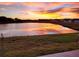 Scenic pond view with colorful sunset reflected in the water, trees and homes along the shoreline at 9577 Sandy Bluffs Cir, Parrish, FL 34219