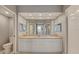 Bright bathroom featuring a double sink vanity with a large mirror and neutral decor at 960 Starkey Rd # 2405, Largo, FL 33771