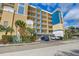 Low-angle view of a multi-story tan and blue condo building with parking at 960 Starkey Rd # 2405, Largo, FL 33771
