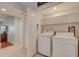 Laundry room with a side by side washer and dryer, storage cabinets, and tile flooring at 960 Starkey Rd # 2405, Largo, FL 33771