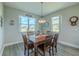Cozy dining room featuring a wood table, chandelier, and bright windows with neighborhood views at 9814 Palazzo St, Seffner, FL 33584