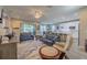 Open-concept living area featuring modern furniture, hardwood flooring, and access to an open kitchen at 9814 Palazzo St, Seffner, FL 33584