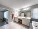 Bright main bathroom with double vanity, large mirror, and stylish tile flooring at 9814 Palazzo St, Seffner, FL 33584